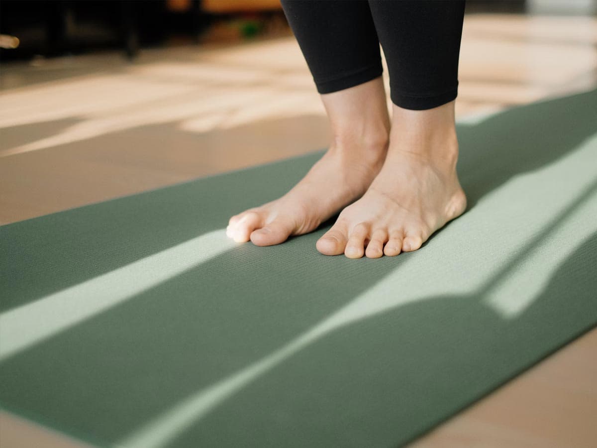 Feet standing on yoga mat