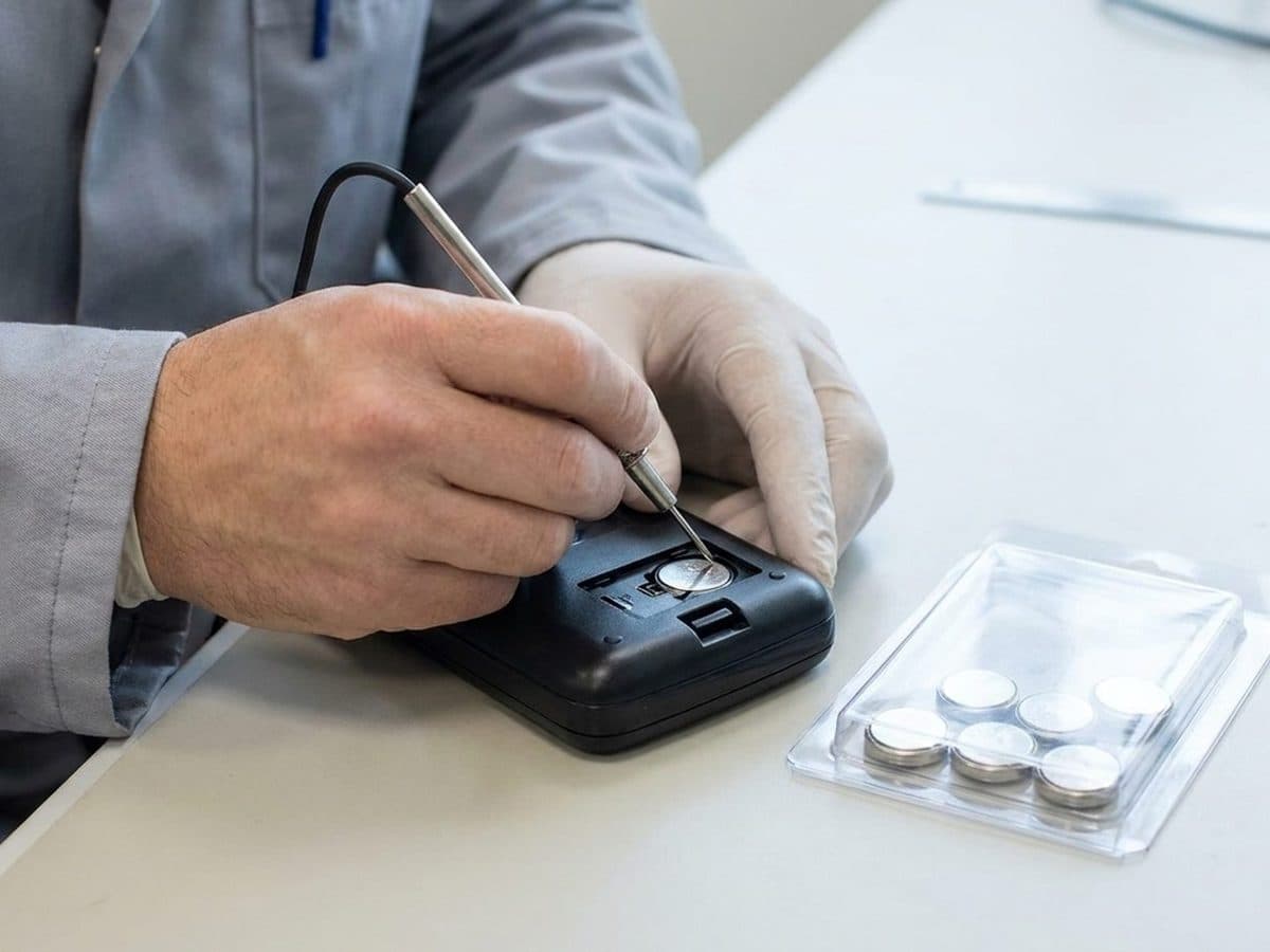 Product-safety engineer testing a secured coin-battery compartment