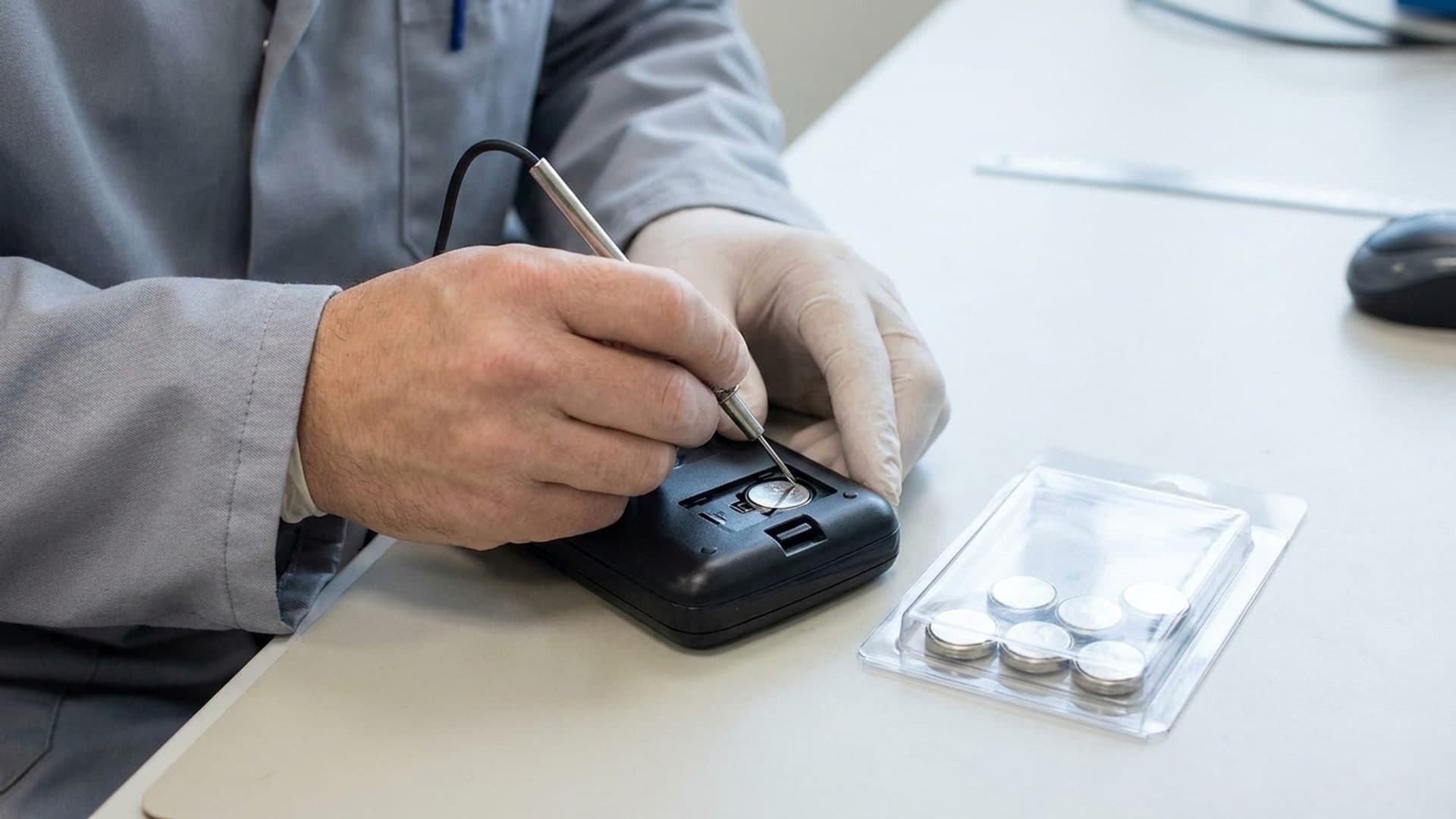 Product-safety engineer testing a secured coin-battery compartment
