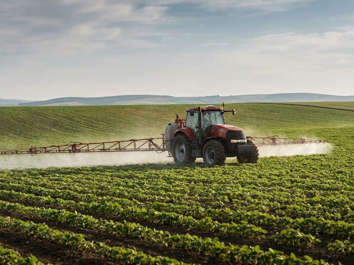 Tractor applying crop treatment across agricultural fields