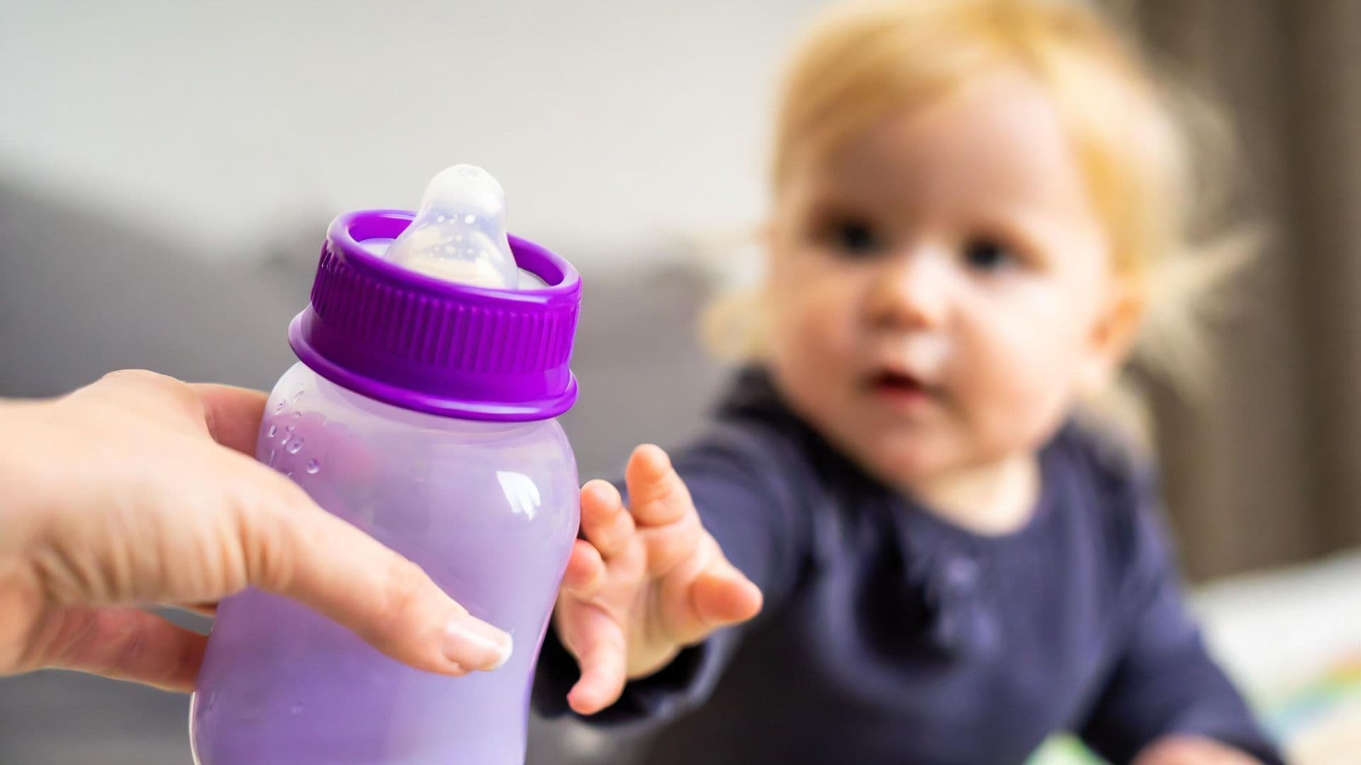 Baby being handed a bottle